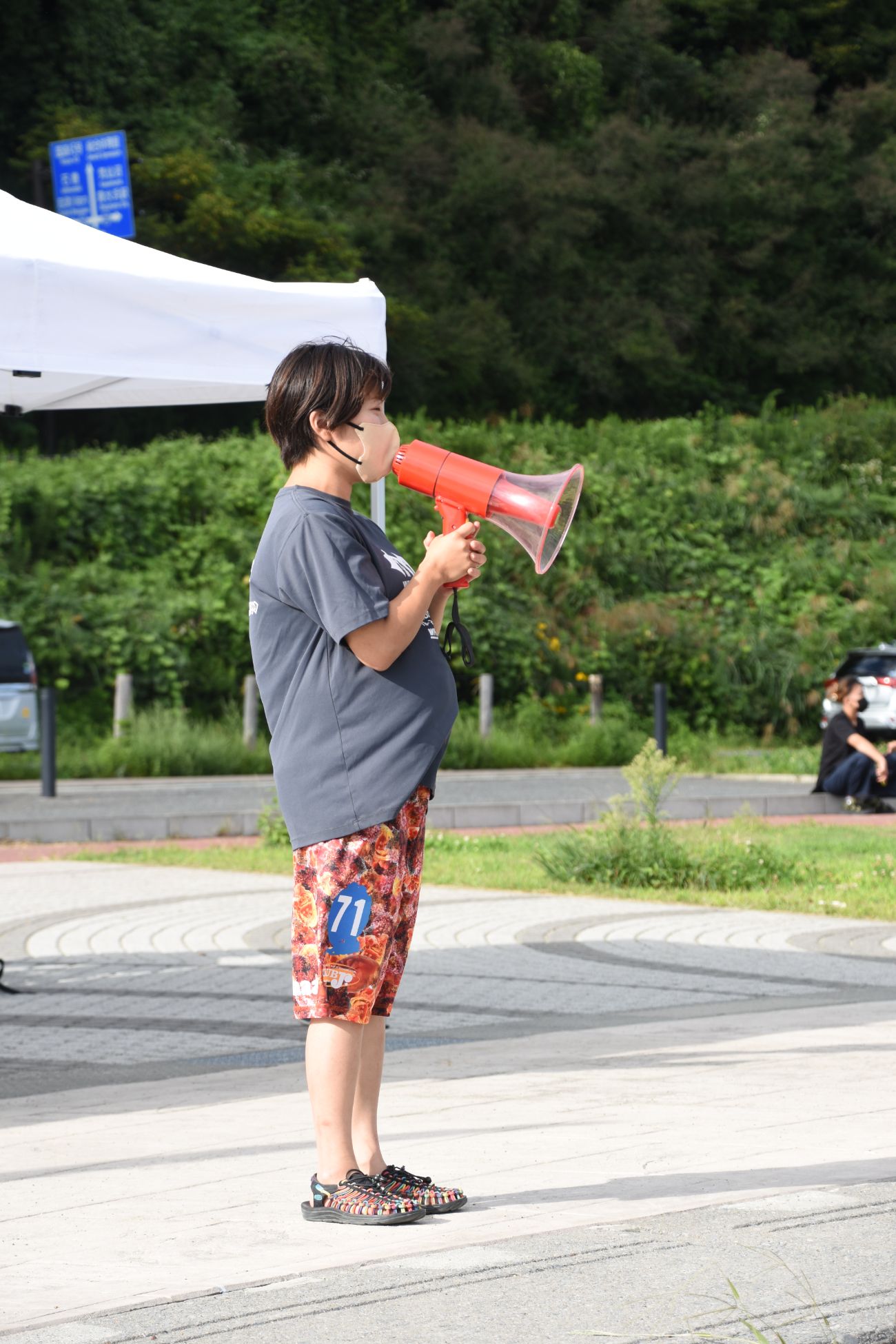 赤いメガホンを使って話をしている佐藤茜さんの写真