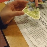 人物が手で黄色の地形パーツを切り取っており、模型に配置するための準備をしている様子の写真