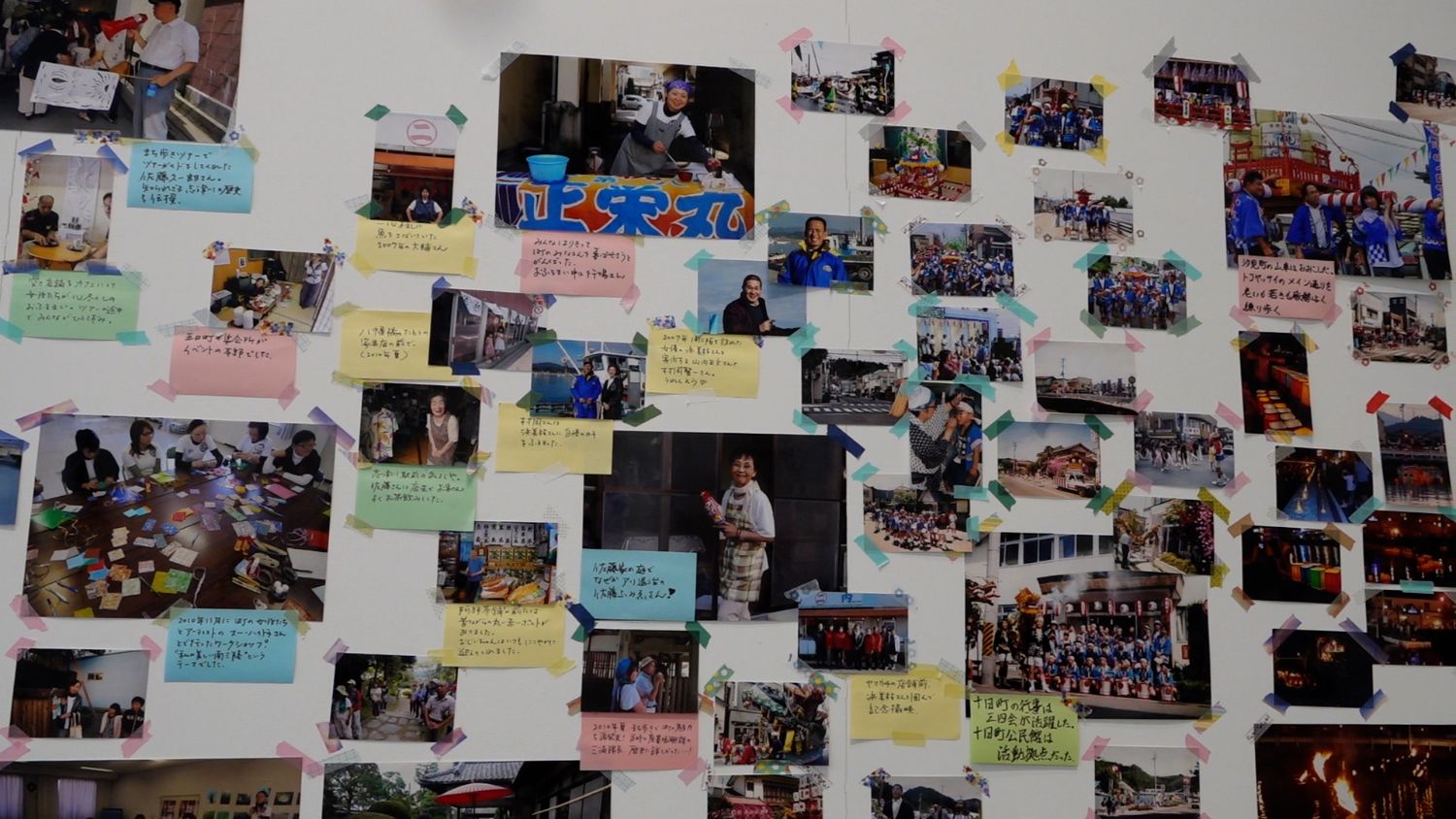 地域住民の笑顔やイベントの様子が写った写真に、それぞれ思い出や背景を伝えるメッセージが添えられて壁に展示されている様子の写真