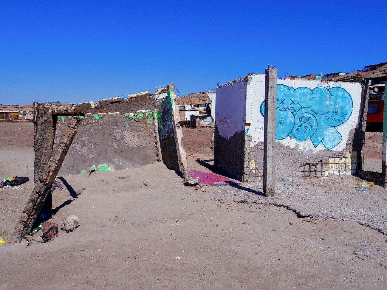 壊れた建物の壁に青い落書きが描かれている写真