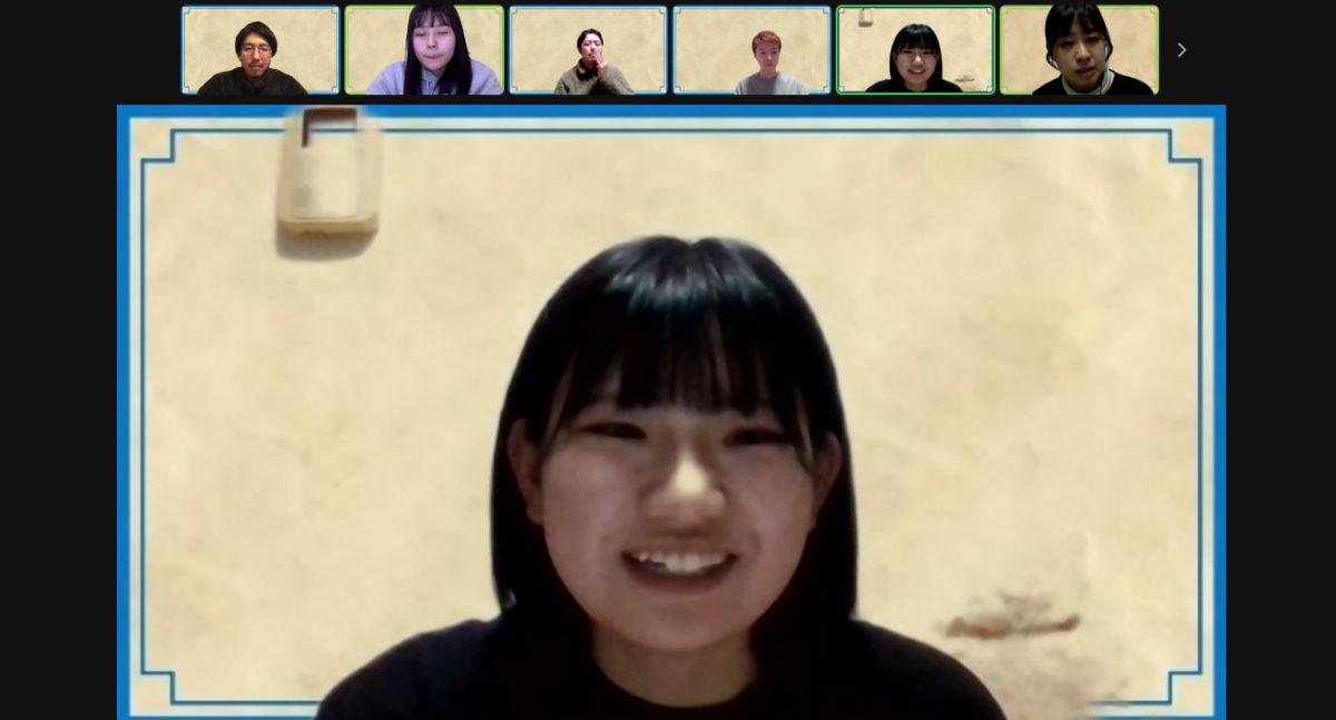 画面に1人の女性が大きく映っており笑顔で話していて、上部には小さな枠で6人の参加者が並んで映っているZoom画面の画像
