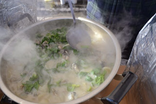 野菜や魚介が煮込まれて湯気が立ち上る鍋を写した写真