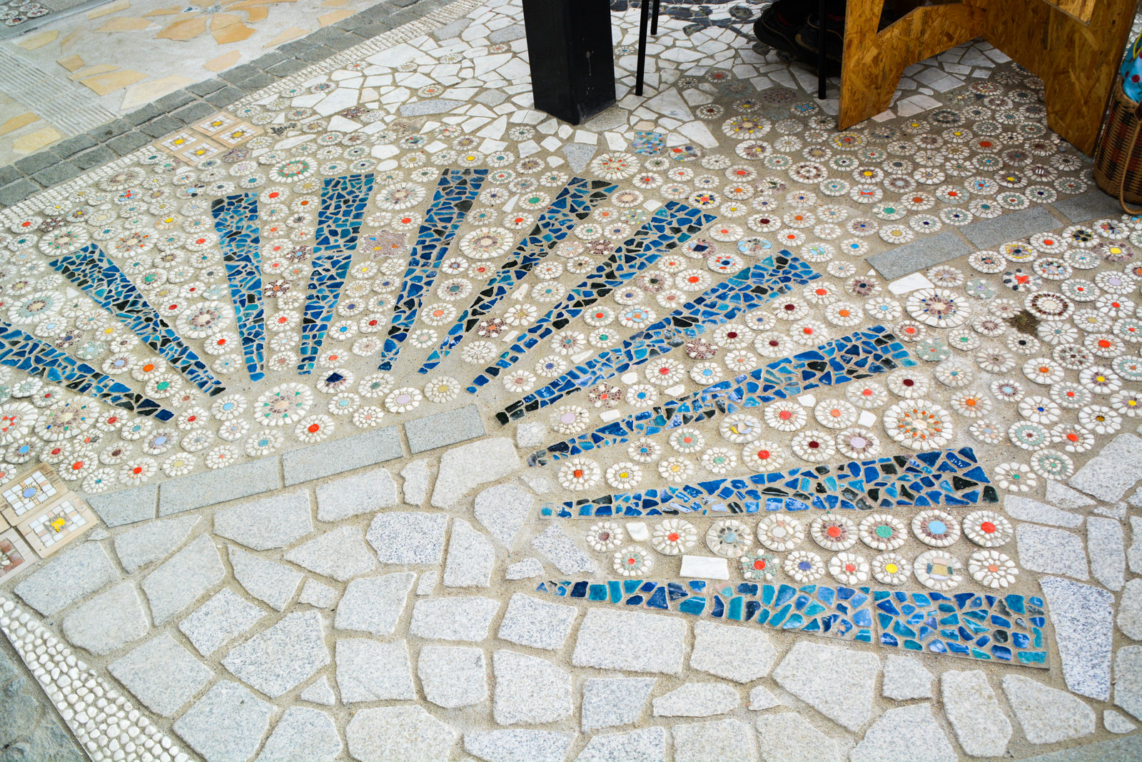 床に埋め込まれた青と白を基調にした扇形のモザイクタイルが、放射状に美しく広がっている写真