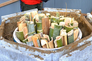 竹をカットしたものを円形の容器の中に隙間なく丁寧に並べた状態を写した、炭焼き前の竹材の準備の写真