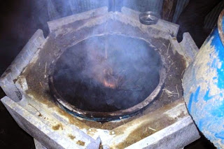 炉の内部が黒く煙が充満し、燃焼中の炭材が見えている様子を上から撮影した、炭化が進んでいる最中の写真