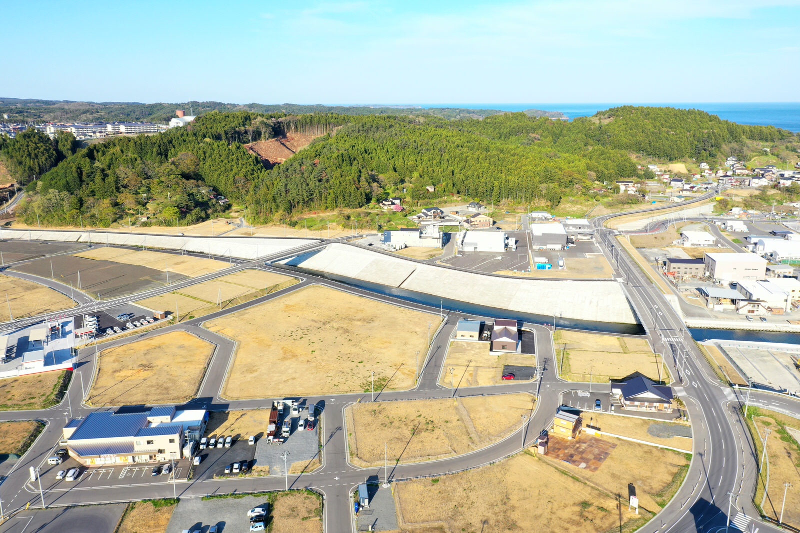 住宅地の中に広い空き地が広がっており、周囲には家々や道路が整然と並ぶ様子を空から撮影した住宅地の空き地の写真