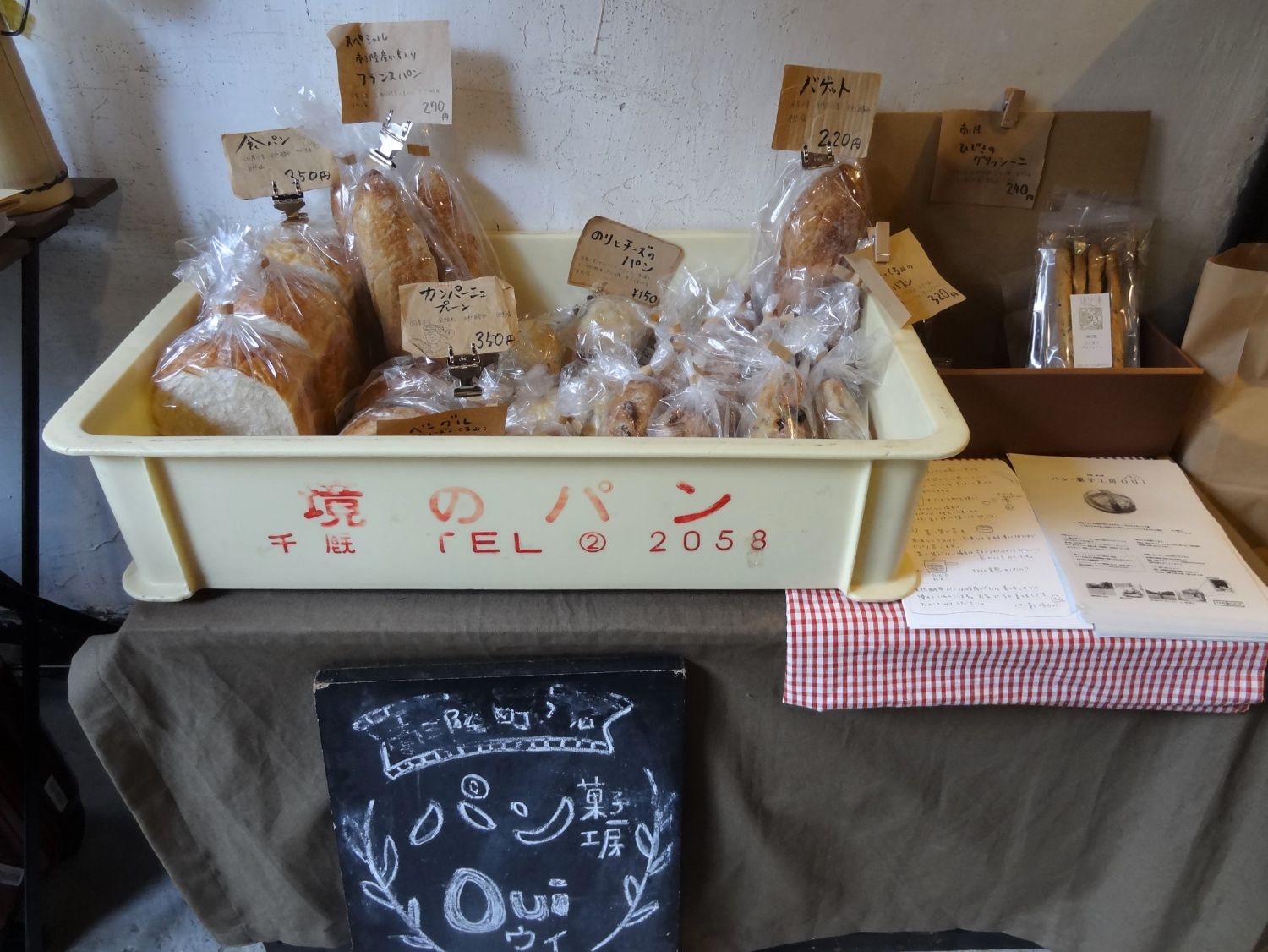 ミニマーケットスペーズでパンケースにたくさんの手作りパンが並べられ販売されている写真