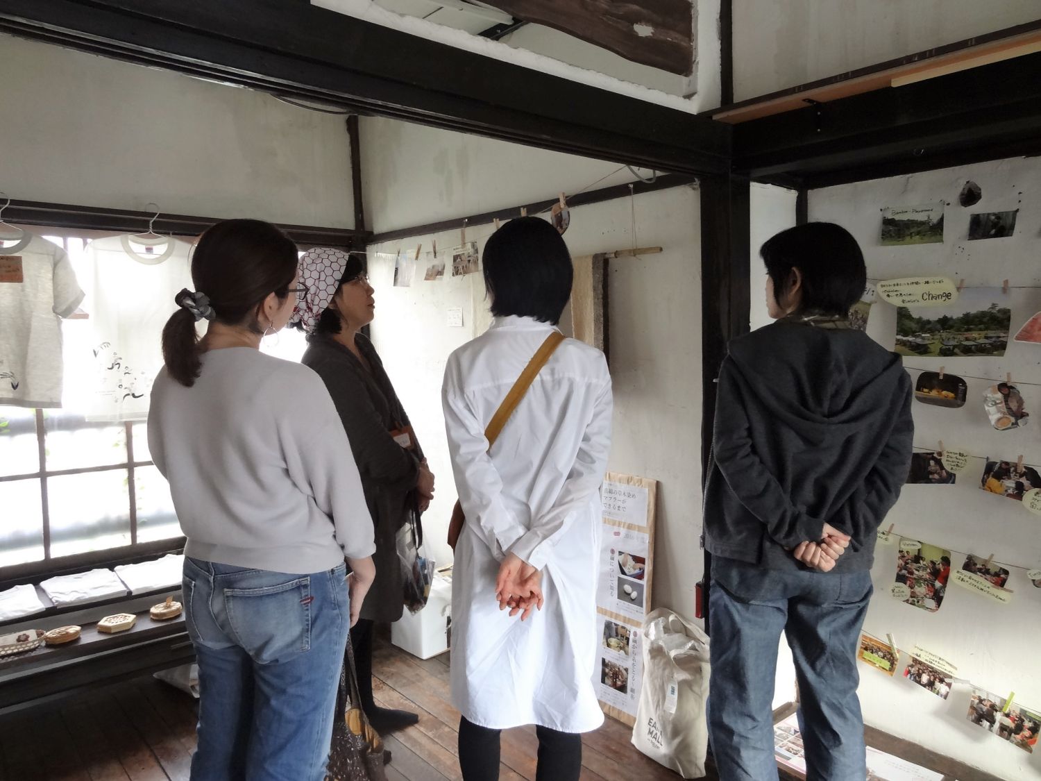 展示スペースにて塩本美紀さんが3人の女性に活動の説明をする様子の写真