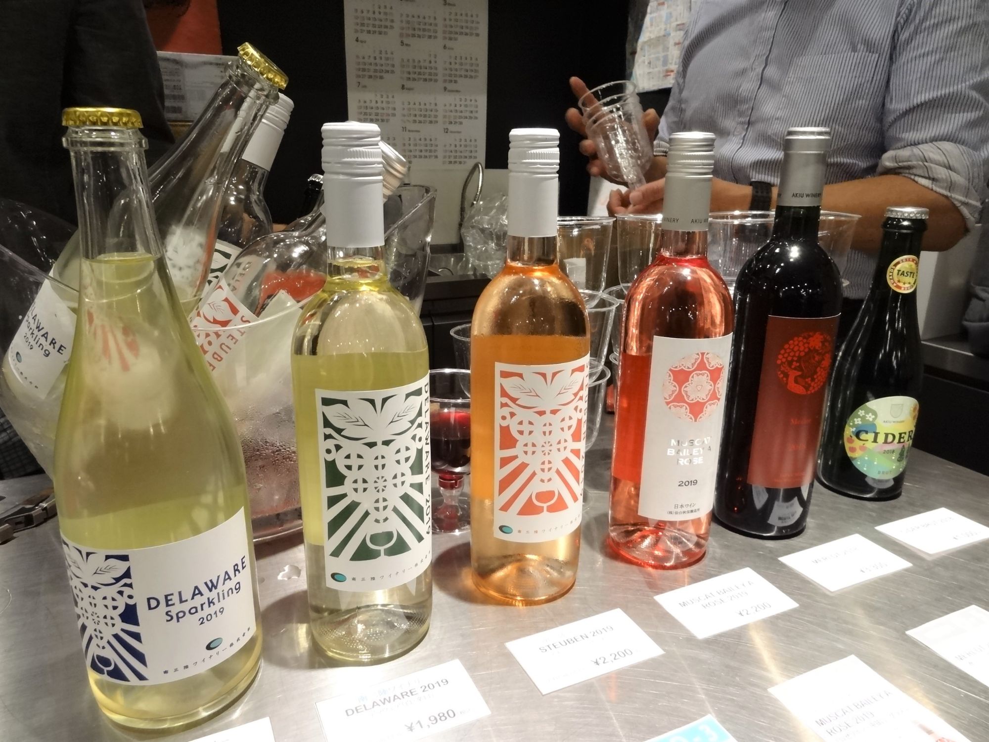 4本の南三陸ワイナリーのワインと、2本の秋保ワイナリーのワインボトルが横一列に並んでいる写真