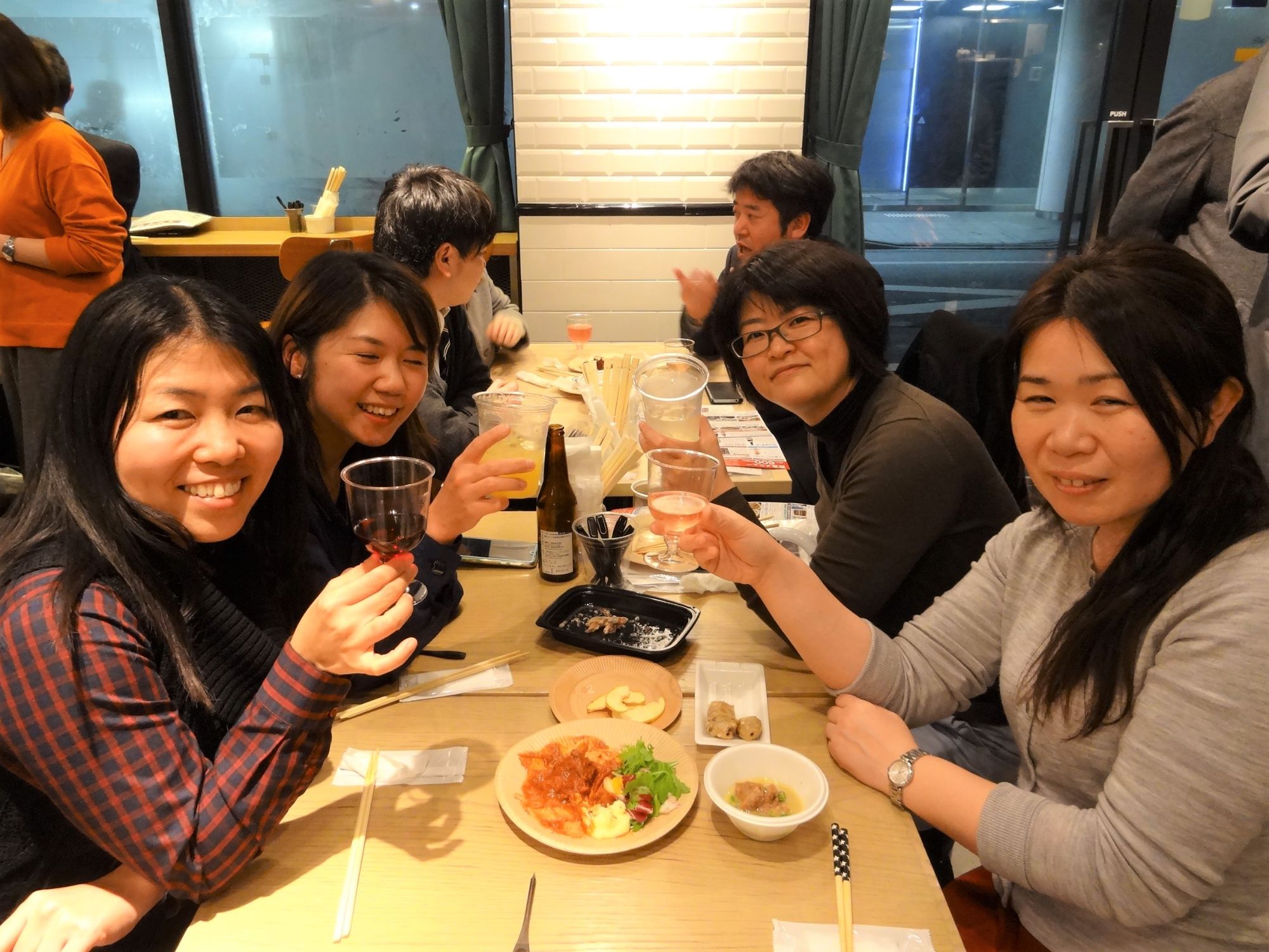 4人の女性グループがグラスを持ちカメラ目線で乾杯を行っている様子の写真