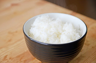 黒色のお椀に盛られた白米の写真