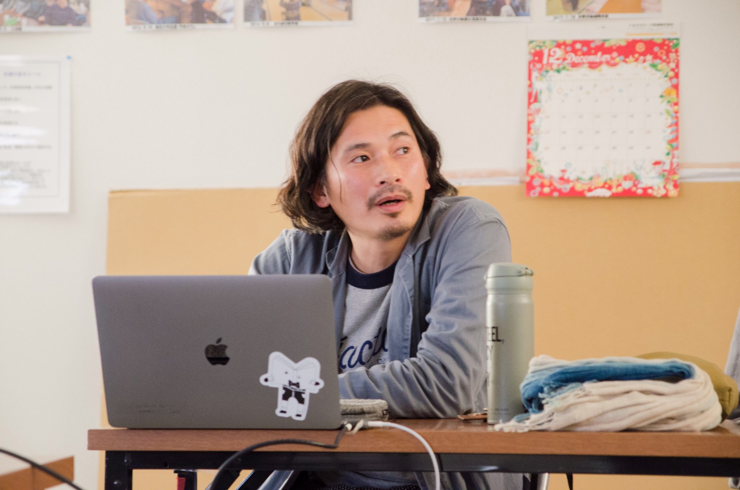 ノートパソコンの前で真剣な表情で話す前川雄一さんの写真