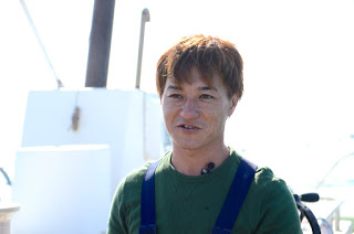 緑の服を着た男性が一人立っている上半身を写した写真