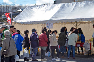 抽選会が行われている白いテントの前に行列ができている様子の写真