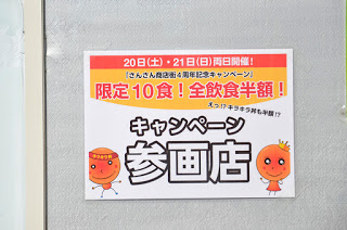 白、オレンジ、赤の配色で大きく「キャンペーン参画店」と書かれたポスターが貼られている壁の写真