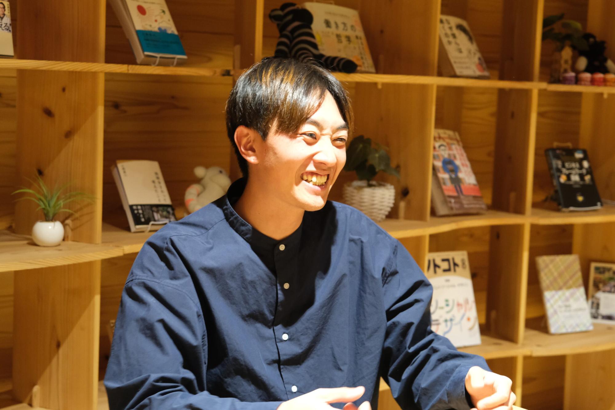 背景には木製の棚があり、満面な笑顔の星空之介さんが話をしている写真