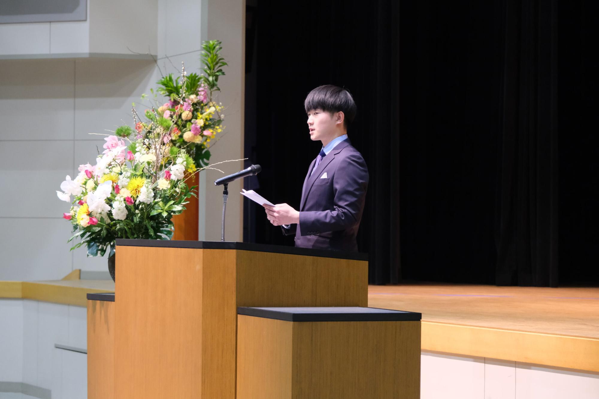 新成人代表の男性が成人の決意を述べている写真