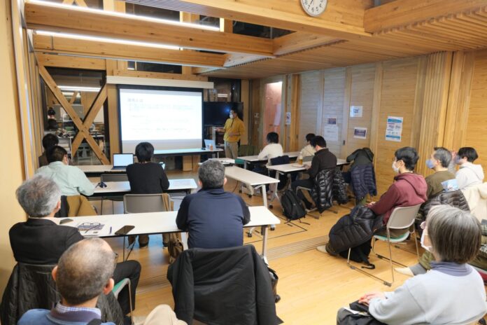 大型スクリーンを前にマスク姿の佐藤講師が立ち、前方の参加者が着席して画面を見つめている自然史講座の写真