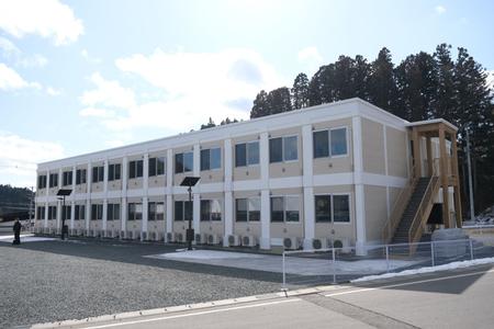 白とベージュを基調とした二階建てで、外には木製の階段が設置されている旭桜寮外観の写真