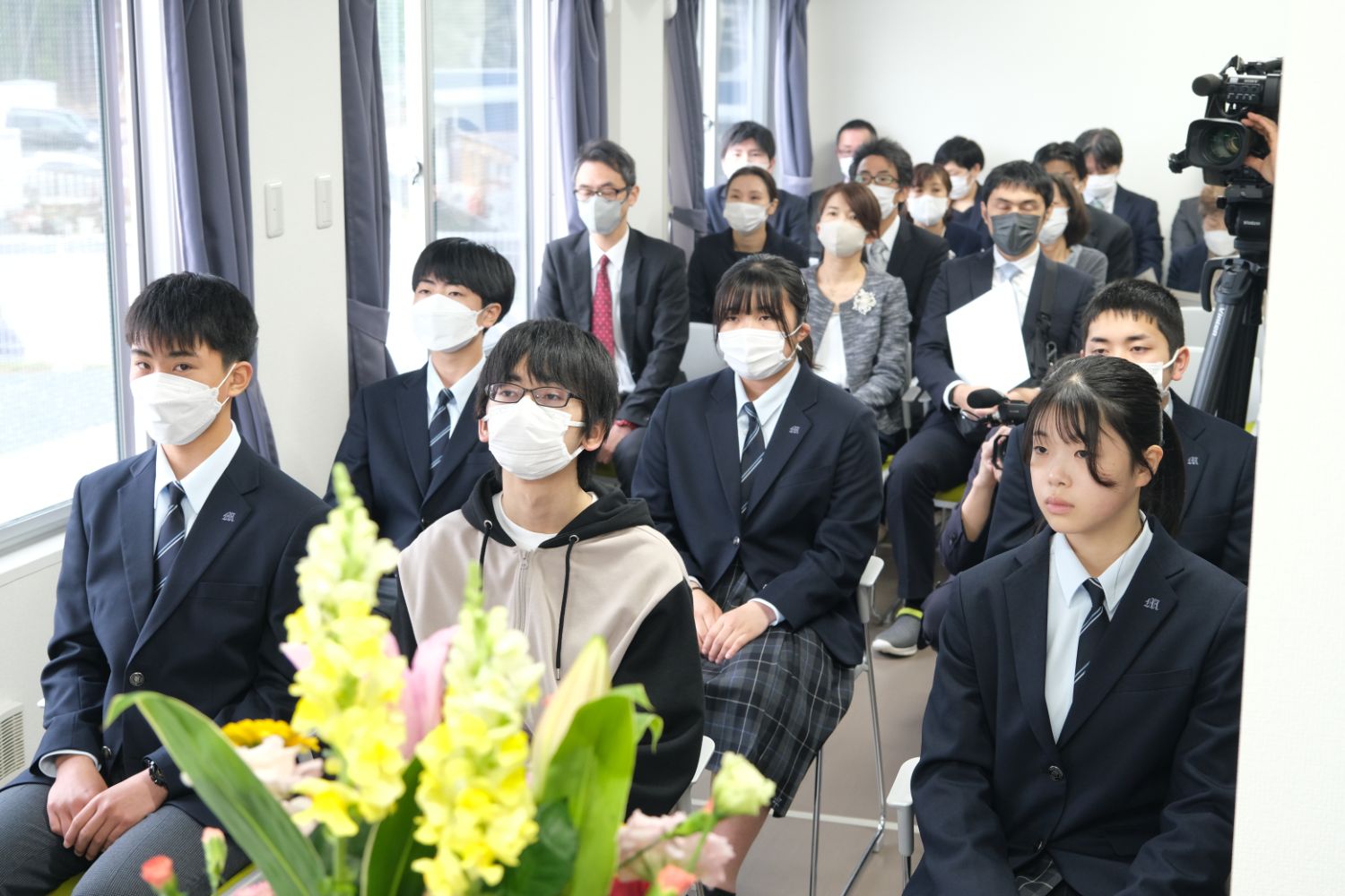 前方に6人の生徒が座り、後ろに保護者らが座っている入寮式の様子の写真