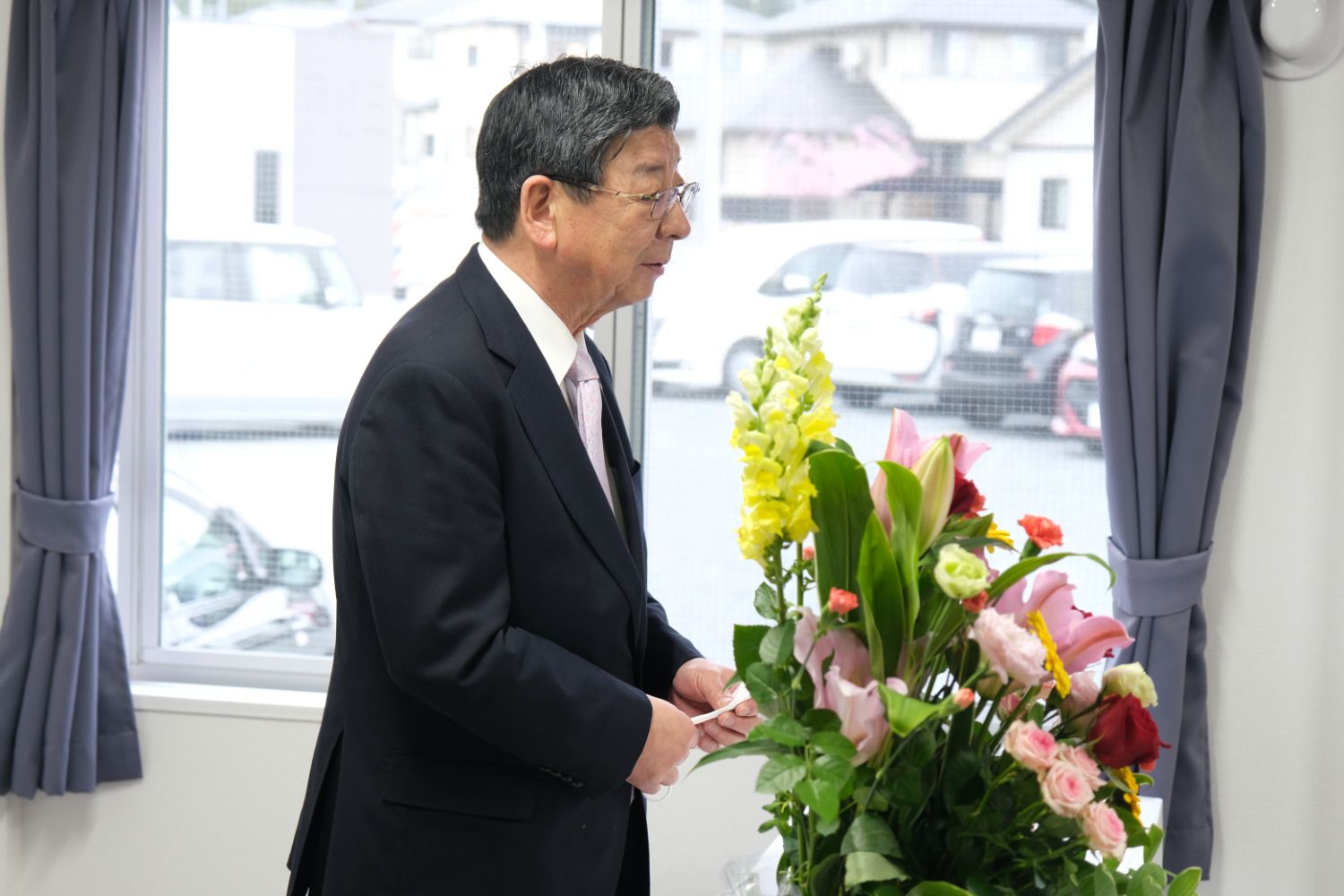 佐藤町長が花のアレンジメントの横に立ちスピーチをしている写真