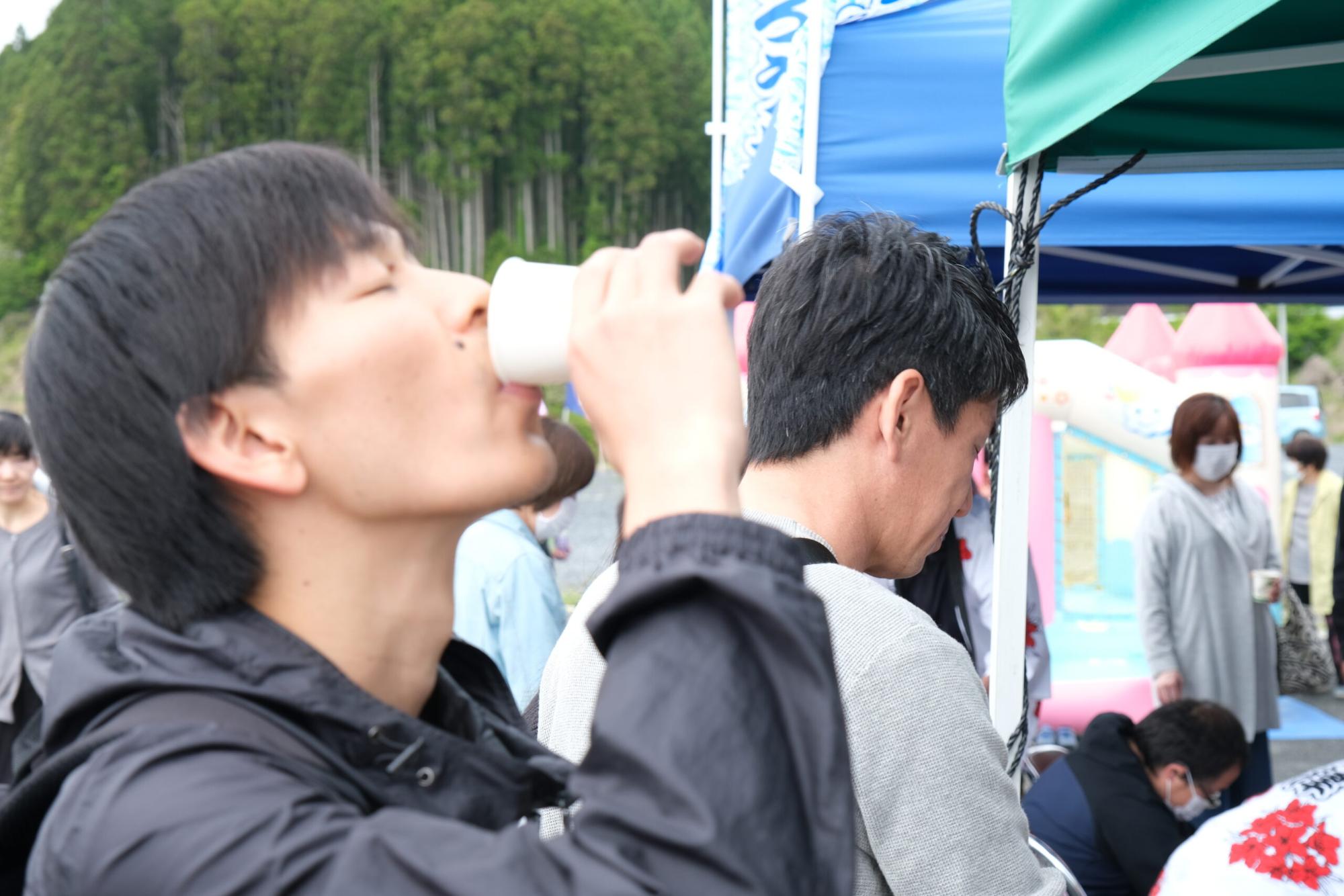 いっちーが紙コップに入ったしろうおを飲んでいる様子の写真