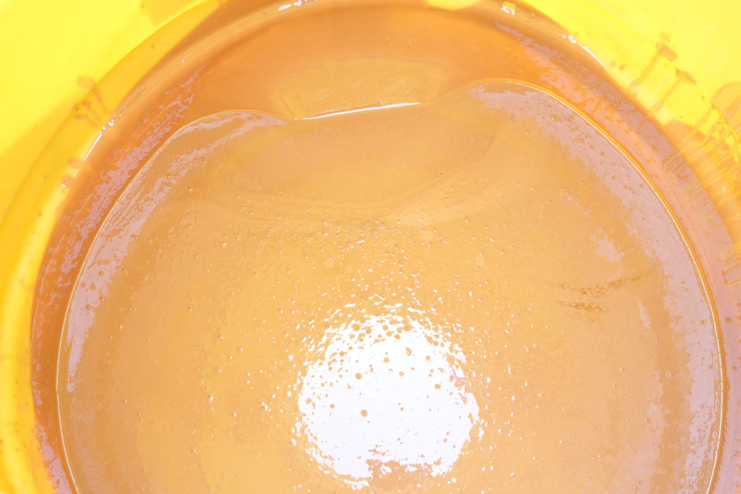 黄色いタンクの中身を上から見たもので、滑らかな黄色い液体が入った写真