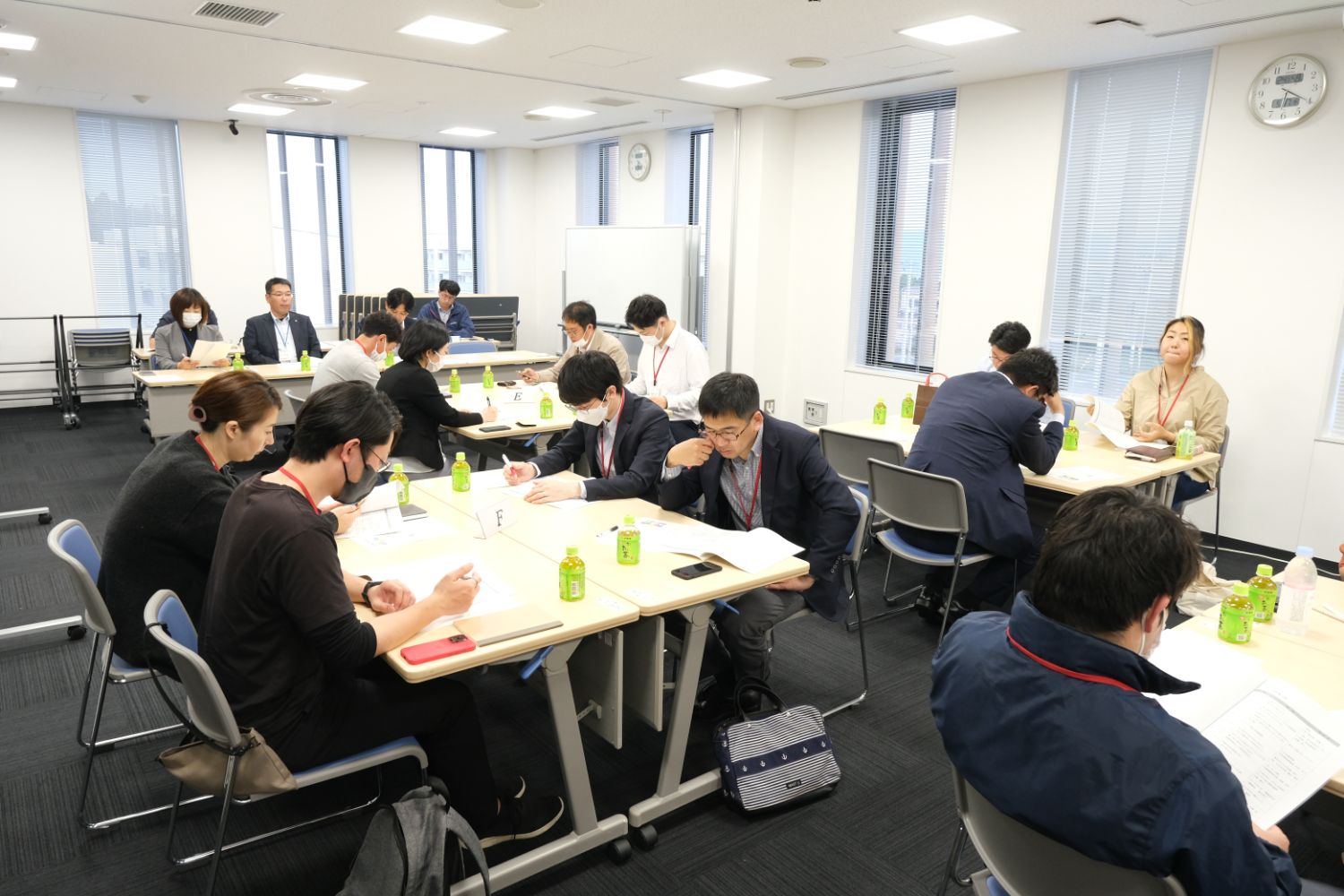 各テーブルで資料を確認しながら少人数のグループに分かれて真剣に議論や意見交換をしている様子の写真