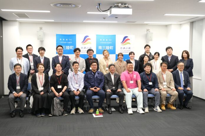 参加者全員が正面を向いて整列し、南三陸町と志津川湾のロゴが掲げられた会場で記念撮影をしている集合写真