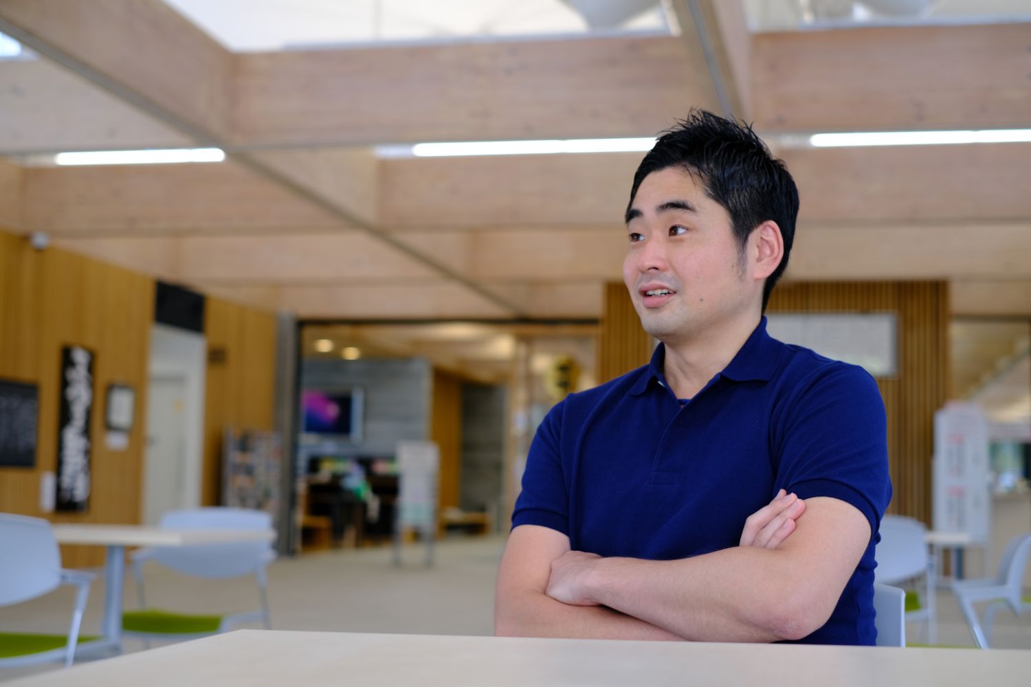 両腕を組んで椅子に座っている上野英律さんの写真