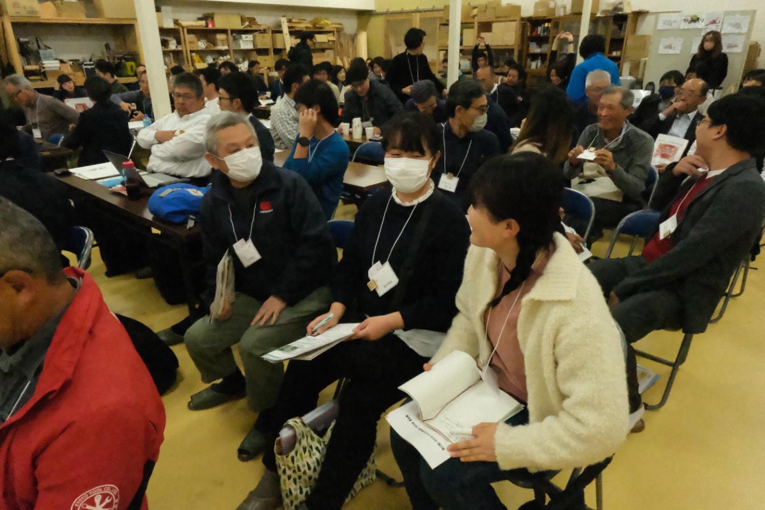 複数の参加者が資料を手にしながら向かい合って話し合っており、和やかな雰囲気の中で交流している研修会のグループワークの写真