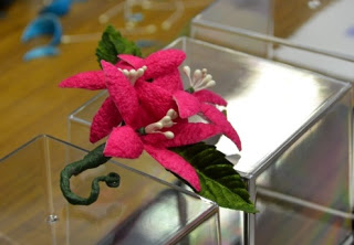 繭を使って作った、ピンク色の花を模したコサージュの完成品の写真