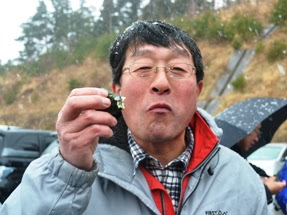 男性が海苔巻きを手に持ち、写っている写真