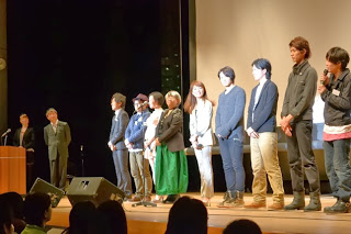 上映後に映画制作に関わったスタッフが壇上に並んで観客に向けて挨拶している写真