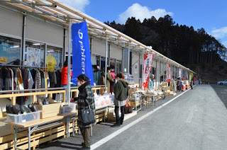 軒先に商品を並べた商店が奥までずっと続いている仮設商店街の写真