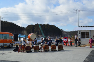 屋外のオープンスペースに和太鼓が並び、太鼓の演奏が行われている写真
