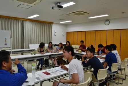 長机を囲んで複数人が座りながら話し合っており、リラックスした雰囲気の中で意見交換をしている様子の写真