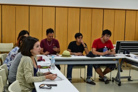 数人の若者たちがメモを取りながら講義を受けている様子が写された室内の写真