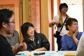 テーブルを囲んで数人が座り、笑顔で話しながら意見交換をしているワークショップ中の写真
