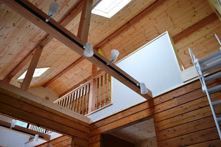 天井が高く開放感のある空間に、梁や照明器具が整備され、木の温もりが感じられる造りになっている室内の写真