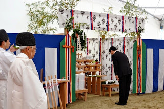 神職が見守る中、参列者の一人が神前に向かって深く礼をして安全祈願をしている写真