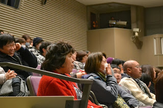 会場内の観客席で笑顔を見せながら上映を楽しんでいる観客たちの様子を写した写真