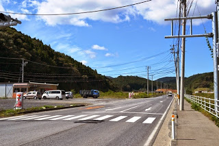 横断歩道がある国道沿いのコンビニに複数の車が停まっている写真