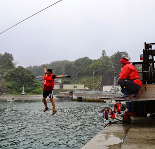 ロープから手を離した瞬間の少年が海に向かって飛び込む直前の場面を捉えた写真