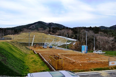 山に囲まれた整地された区画に、木枠が組まれた建設準備が進む住宅予定地の写真