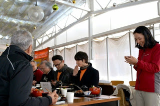 男女数名が集まり机で食事をしている写真