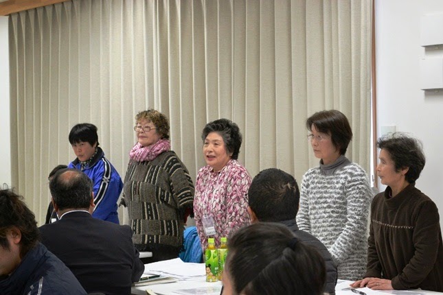 自席で立ち上がった前方に立つ5人の女性が、参加者に向かって自己紹介や発表を行っている様子の写真