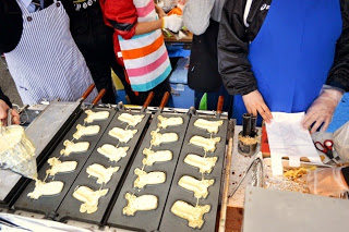 モアイ像の形に生地を流し込んでモアイ焼きを作っている屋台の調理風景を写した写真