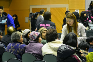 音楽イベントの開演前に、妃乃あんじさんが高齢の参加者に笑顔で話しかけながら交流している様子を写した写真