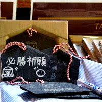 オクトパス君のイラストなどが描かれている「必勝祈願」と白い文字で書かれた黒い絵馬が並んでいる写真